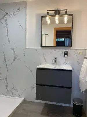 a bathroom with a sink and a mirror at Apartamentos Ciudad Santiago in Santiago de Compostela