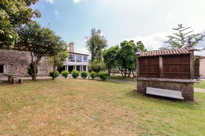a house with a bench in the yard at Casa Grande de Cornide Santiago de Compostela in Teo