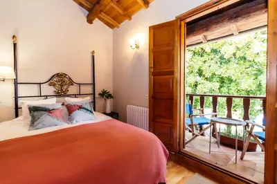 a bedroom with a bed and a balcony at Casa Grande de Cornide Santiago de Compostela in Teo