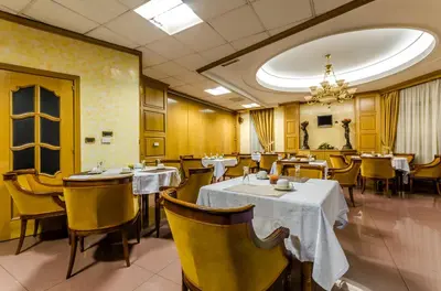 a restaurant with tables and chairs and a chandelier at Hotel Princess in Ourense