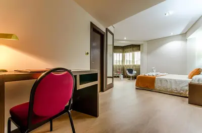 a room with a desk and a red chair at Hotel Princess in Ourense