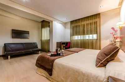 a hotel room with a bed and a couch at Hotel Princess in Ourense
