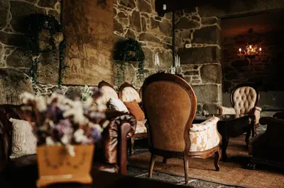 a group of chairs in a room with a stone wall at Casa Grande Do Bachao in Santiago de Compostela