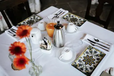 a table with a white table with flowers in a vase at Casa Grande Do Bachao in Santiago de Compostela