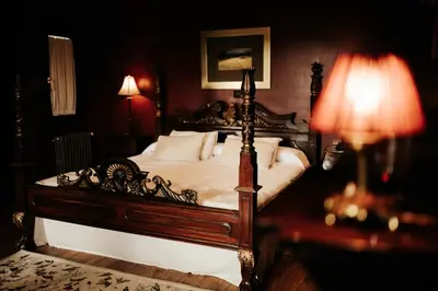 a bedroom with a wooden bed with white sheets and pillows at Casa Grande Do Bachao in Santiago de Compostela