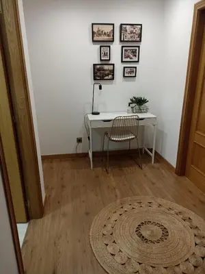a room with a desk and a chair and a rug at EL ATICO in Caldas de Reis