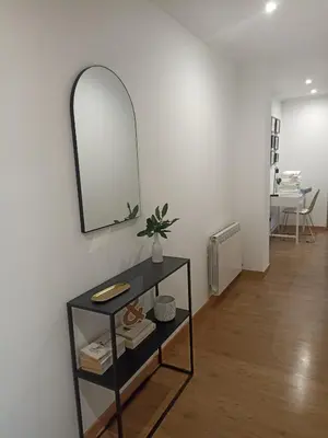 a mirror on a wall next to a shelf with a plant at EL ATICO in Caldas de Reis