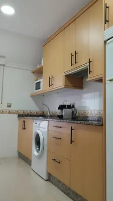a kitchen with a washer and a washing machine at EL ATICO in Caldas de Reis