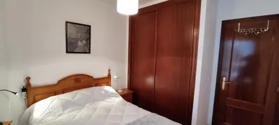 a bedroom with a bed next to a wooden door at MIRADOR DEL EO in Ribadeo