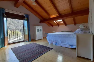 a bedroom with a bed and a large window at Casa da Pilar - A Ponte in Portomourisco