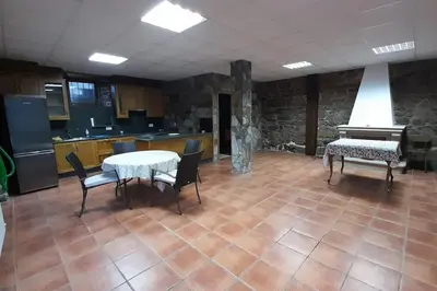 a kitchen with a table and chairs and a piano at Casa da Pilar - A Ponte in Portomourisco