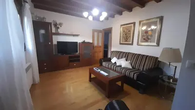 a living room with a couch and a tv at Casa da Pilar - A Ponte in Portomourisco