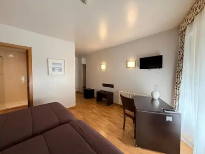 a living room with a couch and a dining room at Hotel Bouza in Ribadeo