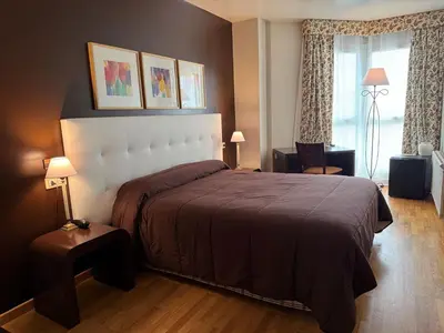 a bedroom with a large bed and a window at Hotel Bouza in Ribadeo