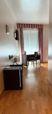a living room with a table and a desk at Hotel Bouza in Ribadeo