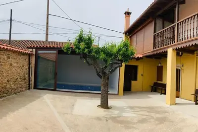 a tree in a courtyard next to a building at Astorga. León. Piscina. Casa Val de San Lorenzo. in Val de San Lorenzo