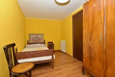 a bedroom with yellow walls and a bed and a table at Astorga. León. Piscina. Casa Val de San Lorenzo. in Val de San Lorenzo