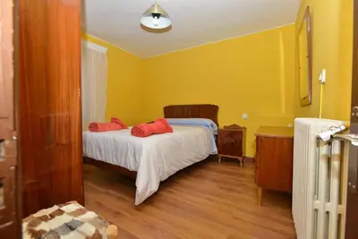 a bedroom with a bed with red pillows on it at Astorga. León. Piscina. Casa Val de San Lorenzo. in Val de San Lorenzo