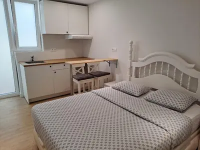 a bedroom with two beds and a table and a kitchen at VISTAS MURALLA CENTRICO EN ZONA PEATONAL Wi-fi VUT LU 3270 in Lugo