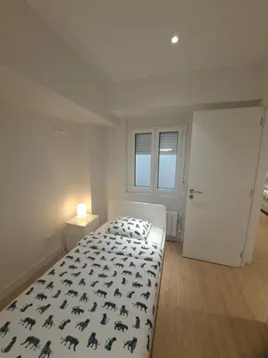 a bedroom with a bed with a black and white comforter at VISTAS MURALLA CENTRICO EN ZONA PEATONAL Wi-fi VUT LU 3270 in Lugo