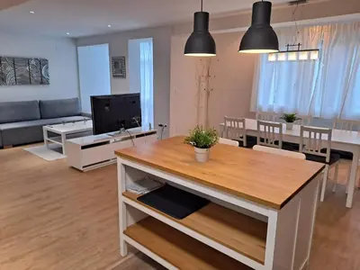 a kitchen and living room with a table and a couch at VISTAS MURALLA CENTRICO EN ZONA PEATONAL Wi-fi VUT LU 3270 in Lugo