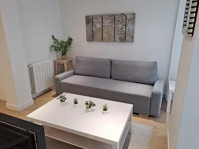 a living room with a couch and a table at VISTAS MURALLA CENTRICO EN ZONA PEATONAL Wi-fi VUT LU 3270 in Lugo