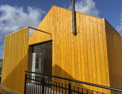 a yellow facade of a building with a black fence at Alda Cabanas Nature in Cabañas