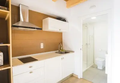 a white kitchen with a sink and a shower at Alda Cabanas Nature in Cabañas