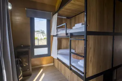 a room with three bunk beds and a window at Alda Cabanas Nature in Cabañas