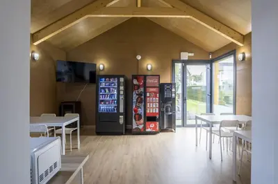 a restaurant with a soda machine and tables and chairs at Alda Cabanas Nature in Cabañas