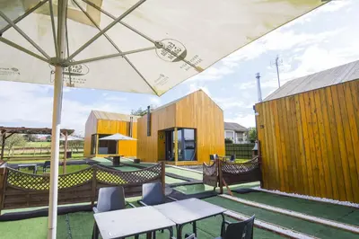 an outdoor patio with tables and an umbrella at Alda Cabanas Nature in Cabañas