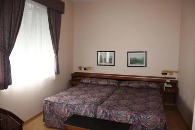 a hotel room with a bed and a window at Hotel Las Sirenas in Viveiro