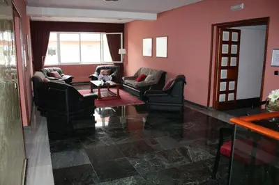 a living room with pink walls and couches and a table at Hotel Las Sirenas in Viveiro