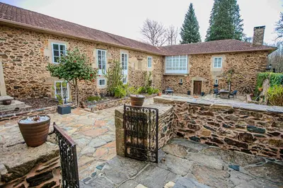 an exterior view of a stone house with a gate at Pazo Xan Xordo in Lavacolla