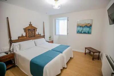 a bedroom with a large bed and a window at Pazo Xan Xordo in Lavacolla