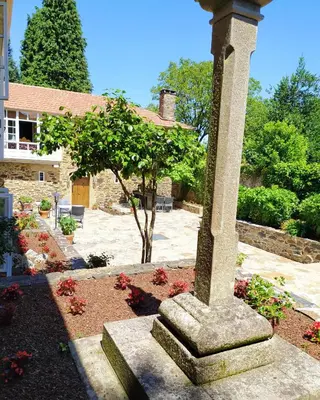 a stone pillar in the middle of a garden at Pazo Xan Xordo in Lavacolla