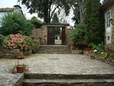 a stone walkway leading to a house with a door at Pazo Xan Xordo in Lavacolla