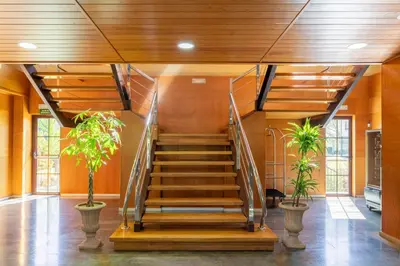 a spiral staircase in a building with two plants at IBERIK Augas Santas Balneario & Golf in Pantón
