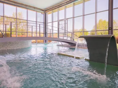 a water fountain in a building with a bridge at IBERIK Augas Santas Balneario & Golf in Pantón