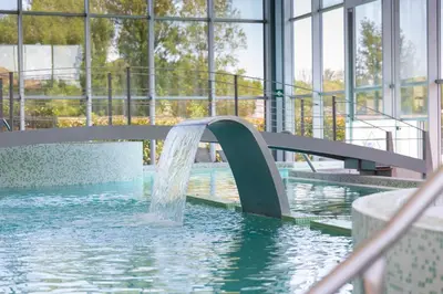 a water slide in a building with a pool at IBERIK Augas Santas Balneario & Golf in Pantón