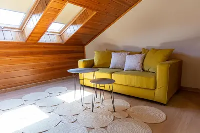 a living room with a yellow couch and two tables at IBERIK Augas Santas Balneario & Golf in Pantón