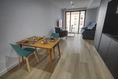 a kitchen and living room with a table and chairs at HAVANAAPARTAMENTOS in Puerto de Vega