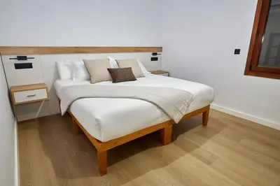 a bedroom with a large bed with white sheets and pillows at HAVANAAPARTAMENTOS in Puerto de Vega