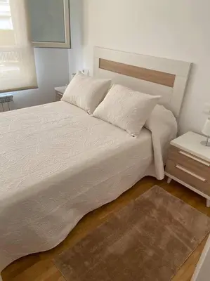 a bedroom with a large white bed and a nightstand at Carmarez in Puerto de Vega