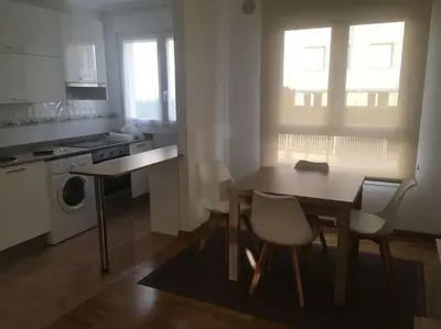 a kitchen with a table and chairs and a kitchen with a stove at Carmarez in Puerto de Vega