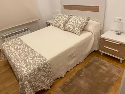 a bed in a small room with a nightstand and a bed sidx sidx sidx at Carmarez in Puerto de Vega