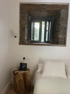 a bedroom with a bed and a mirror on the wall at Hotel Cadario 1925 in Tebongo