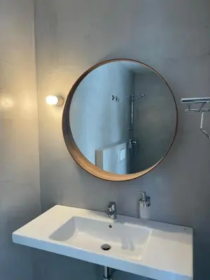 a bathroom with a white sink and a mirror at Hotel Cadario 1925 in Tebongo