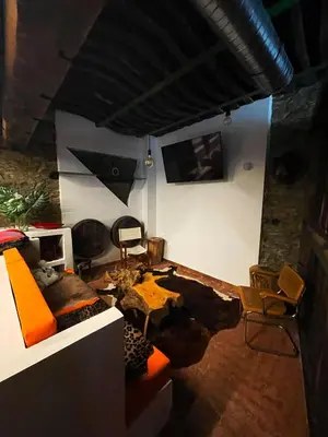 a living room with a couch and a table and chairs at Hotel Cadario 1925 in Tebongo