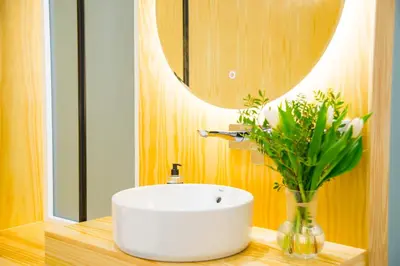 a bathroom with a sink and a vase with a plant at KALIDAS HOSTEL SUITES in Caldas de Reis